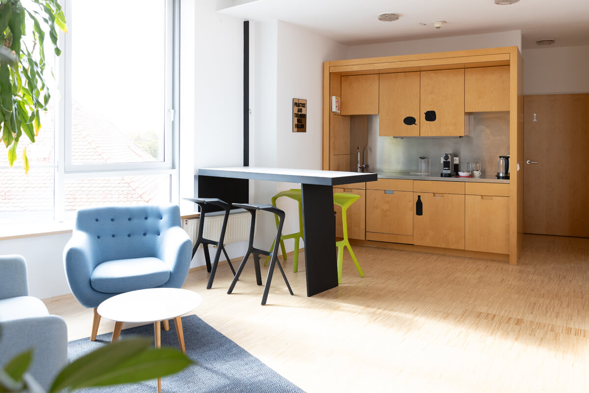 Küchenzeile und Empfangsbereich im Level 4 mit Stehtischen und Sofa